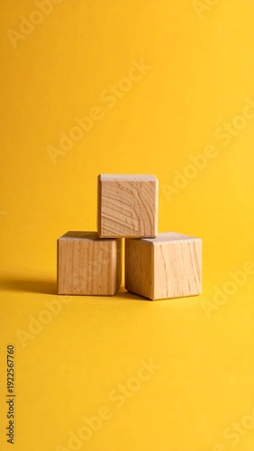 Three wooden cubes stacked on a yellow background