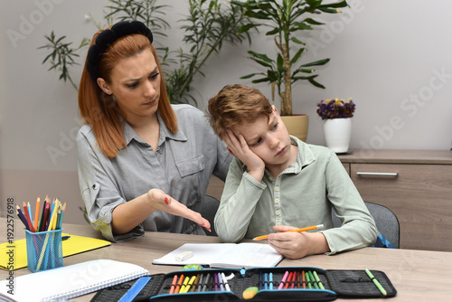  Frustrated woman helping her son with school studies, child feeling stressed and overwhelmed by learning.