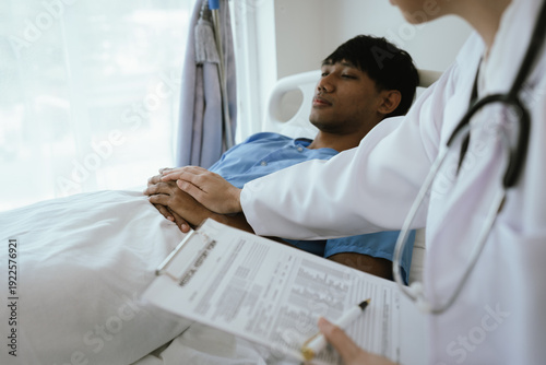 Foto Female doctor reviewing medical records on a clipboard while a male patient rests in a hospital bed during inpatient care