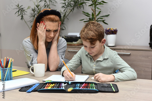  Frustrated woman helping her son with school studies, child feeling stressed and overwhelmed by learning.