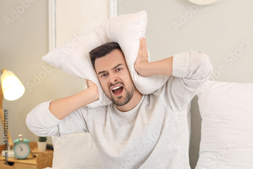 Young man with pillow suffe...
