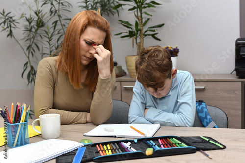  Frustrated woman helping her son with school studies, child feeling stressed and overwhelmed by learning.