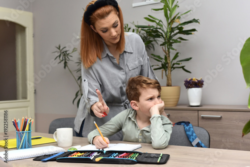  Frustrated woman helping her son with school studies, child feeling stressed and overwhelmed by learning.
