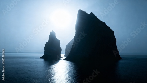 Dramatic Silhouette of Coastal Sea Stacks Rising from the Ocean at Misty Blue Hour, Atmospheric Landscape Photography of Majestic Rocky Cliffs in Foggy Sea with Glowing Sunlight