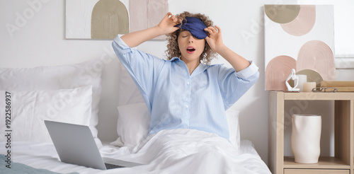 Awake young woman with lapt...