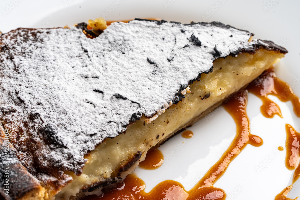 Fototapeta premium Dessert, a traditional French flan with salted caramel on a white plate. Close-up