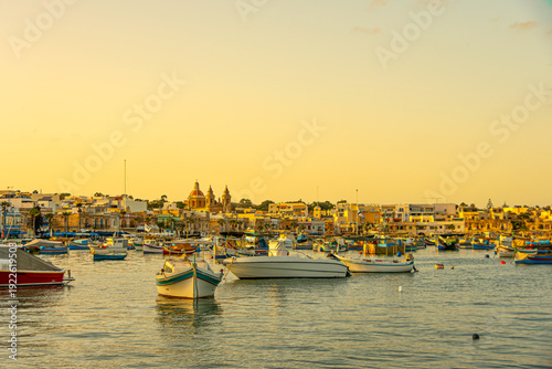 Panoramic view of the sunset in the port of Marsaxlokk with its boats. Malta.