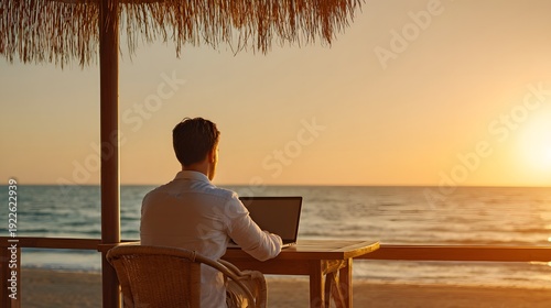 Work From Paradise: A person immersed in work while basking in the beauty of a beachfront, leveraging the captivating ocean view and the warm glow of sunset.