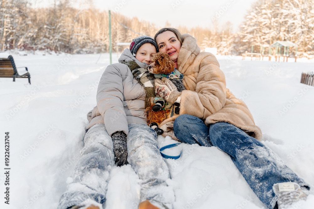 Fototapeta premium Resting mother with teen son lies on snow near forest, faces close, smiles after winter play, warm family bonding, childhood memory, outdoor lifestyle, mental health support, seasonal holiday mood.