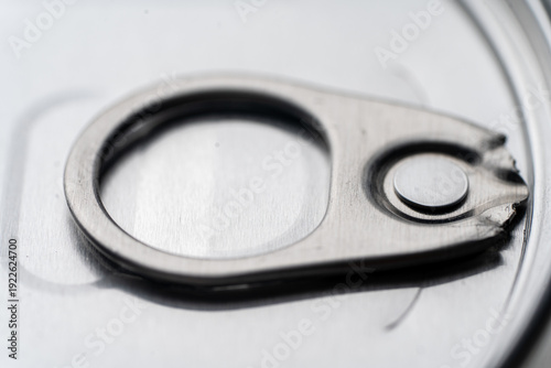 Close-up of a closed metal jar lid with an opening ring, on a white background, perfect for food packaging concepts.