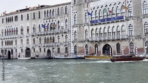Boats navigate venice canal along historic palazzo with passing traffic and scenic views