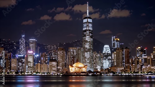 Wallpaper Mural Serene Nighttime Cityscape Featuring Illuminated Skyscrapers Reflecting On Calm Water Surface With Subtle Cloud Movement Over Urban Skyline Torontodigital.ca