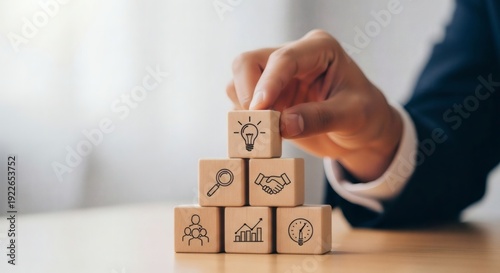 Business Strategy and Smart Solutions. Manager completing pyramid of business icon blocks with lightbulb on top, representing strong leadership, long term growth, and reliable success systems.
