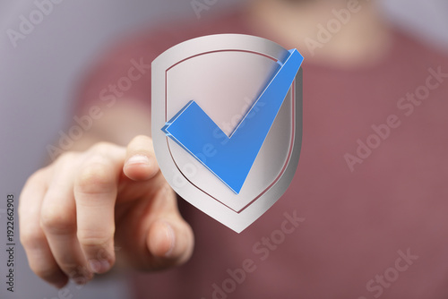 A hand touches a shield wit...