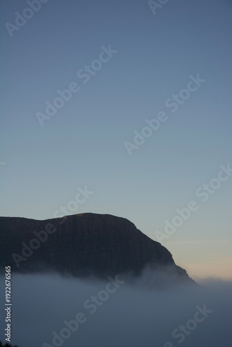 Pic rocheux émergent de la brume matinale, montagnes françaises