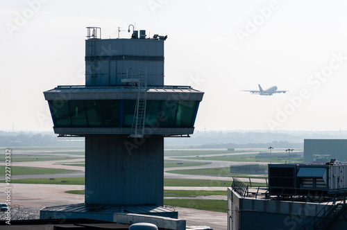 Airbus A380 takes off behind a control tower in hazy/misty conditions