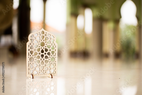 Islamic geometric ornament on mosque floor with blurred arch background. Elegant Ramadan and Eid Mubarak religious decoration concept