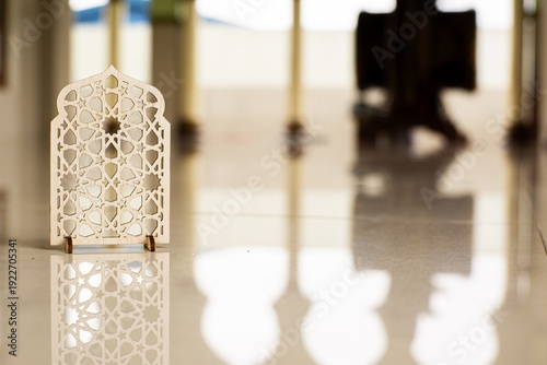 Islamic geometric ornament on mosque floor with blurred arch background. Elegant Ramadan and Eid Mubarak religious decoration concept