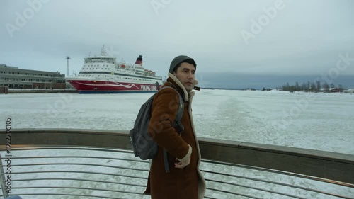 Wallpaper Mural A tourist man stands on a boat, observing the frozen Baltic Sea as it stretches between Helsinki and Suomenlinna. Torontodigital.ca