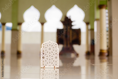 Islamic geometric ornament on mosque floor with blurred arch background. Elegant Ramadan and Eid Mubarak religious decoration concept