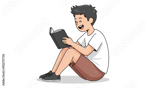 Happy young boy reading a book while sitting on floor