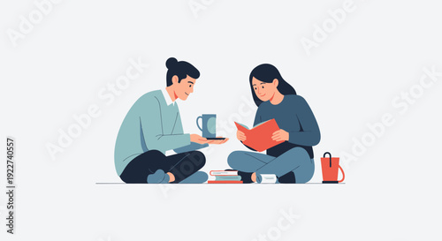 Two women sitting on floor enjoying reading and drinking tea together.