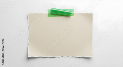 Torn paper note with green clip attached to white background for creative design purpose usage