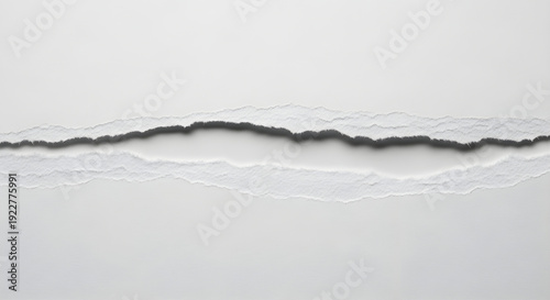 Torn white paper edge with rough texture and uneven rip on plain background surface