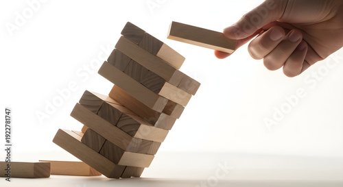 Hand carefully placing wooden block in precarious jenga game strategic skill challenge