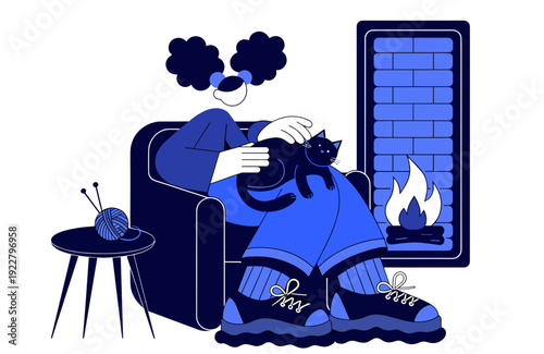 Person sitting in armchair with cat by cozy fireplace  