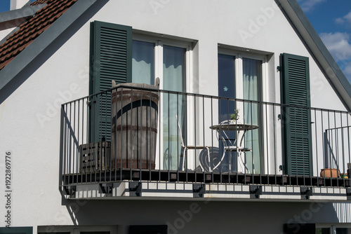 An iron balcony on a big, white family house in Germany.