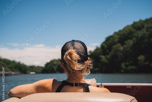 Quadro su tela Woman sitting on pontoon boat looking at lake and hills