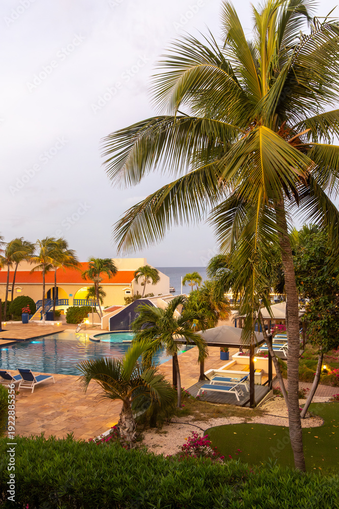 Fototapeta premium Tropical luxury resort pool with palm trees at sunset