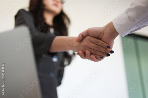 Obraz na plátně Businesspeople shaking hands in the meeting over a desk for the start or culmination of a professional relationship or negotiation