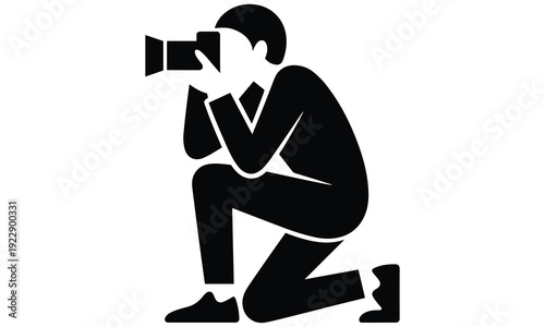 Professional photographer kneeling and capturing a moment with a camera in a focused and skilled manner.