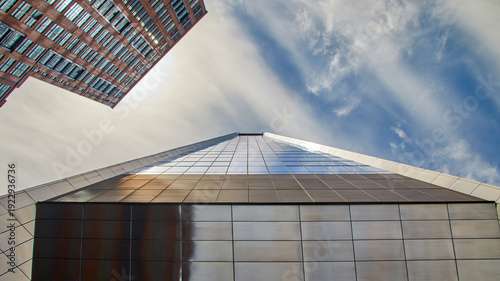 Fotografie a facade, mirror-smooth and utopian, rises high into the sky