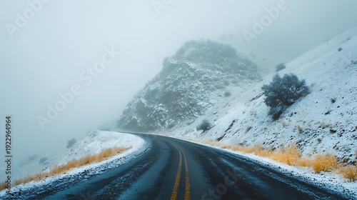 Winding road through a snowy mountain pass in foggy weather