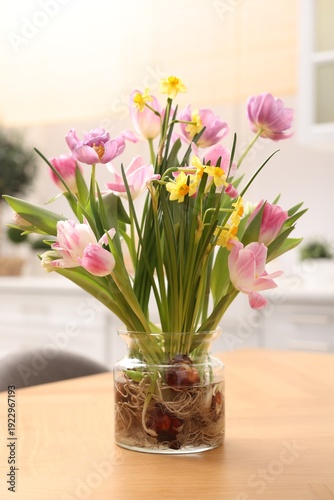 Beautiful spring flowers in vase on wooden table indoors, closeup