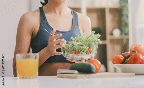 Bild auf Leinwand Fit young Asian women in activewear sitting on yoga mat and eating fresh vegetable salad after workout, representing clean eating, fitness lifestyle, wellness routine and health balance
