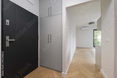Fotografi Modern apartment entrance hall with grey wardrobe and door