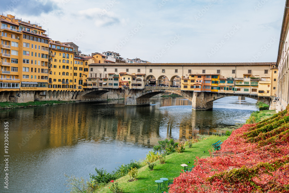 Fototapeta premium Famous historic Ponte Vecchio bridge and old buildings along the Arno river in Florence Italy