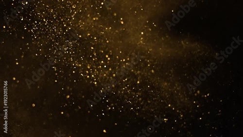 Shimmering golden particles floating on a dark abstract background