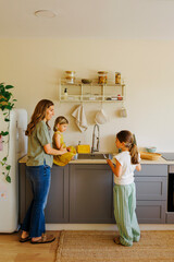 Family washing dishes together in modern kitchen