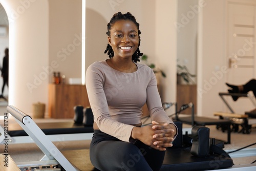 Portrait of smiling black woman looking at camera in fitness studio
