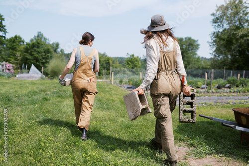 two farmers working together and moving cinder blocks