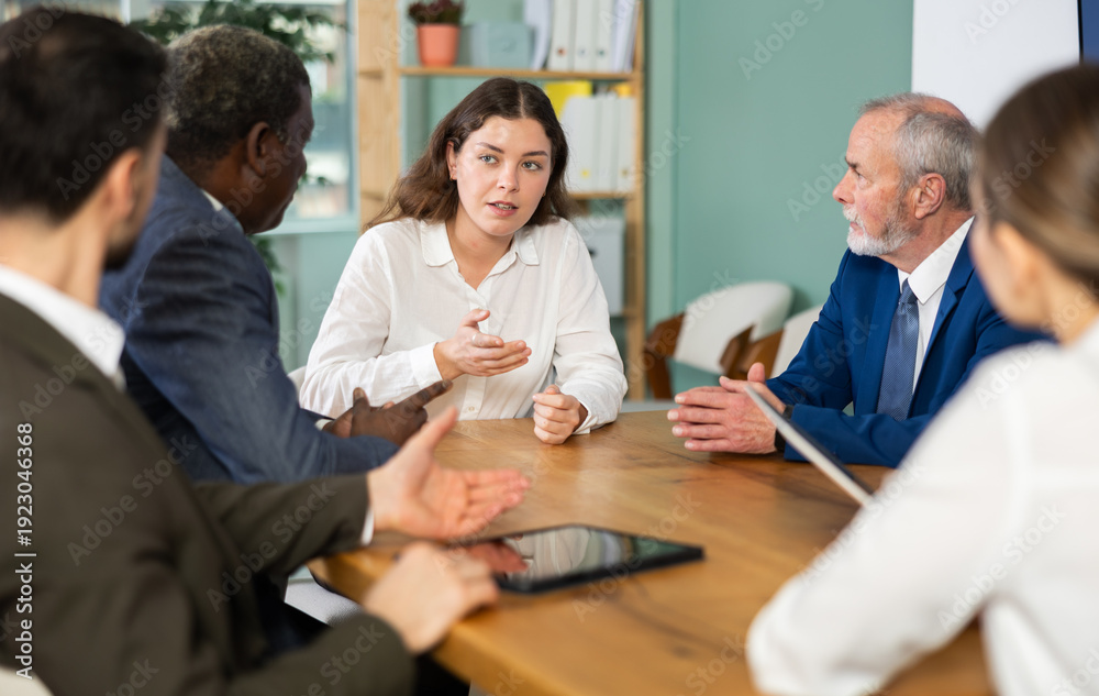 Obraz premium Business partners or employees of corporation sitting at table, talking and discussing. Staff or co-founder during discussion of companys development strategy, collegial decision, coaching course. .