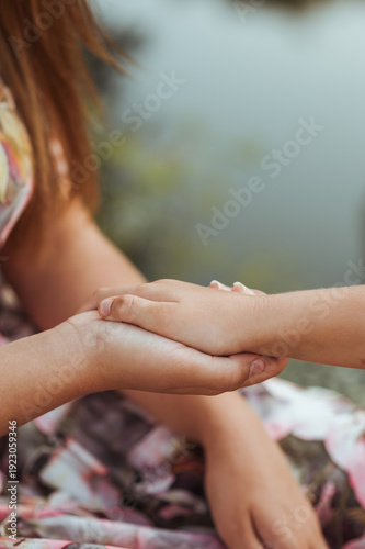 Child holding adult hand close-up, symbol of trust and protection, copy space for text