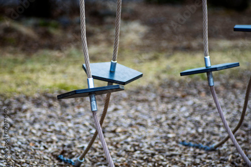 Картината върху платно Close-up of modern outdoor playground equipment with climbing ropes and black st