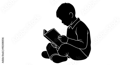 A silhouette of a young boy sitting and engrossed in reading a book.