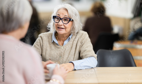 Tableau sur toile Two mature women having nice conversation at cafe, drinking coffee, friend meeting
